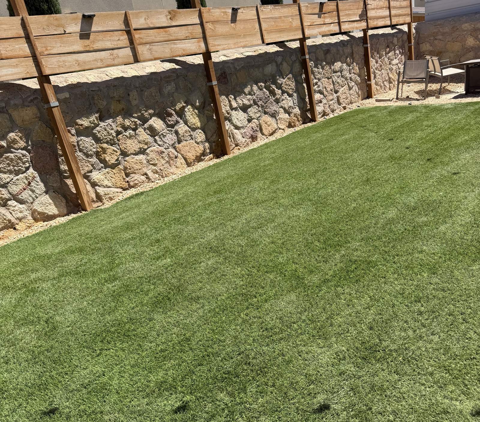 Freshly cleaned turf along a rock wall